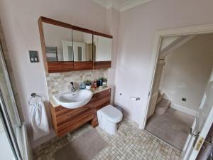 a bathroom with a sink and a toilet at Great stay in a beautiful and cosy house in Bournemouth