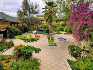 einen Innenhof mit Stühlen, Bäumen und Blumen in der Unterkunft Dodoma Rock Hotel Ltd in Dodoma