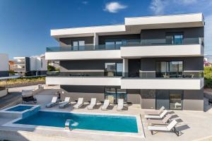 a house with a swimming pool in front of it at Apartments Ante in Novalja