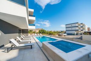 a swimming pool on the roof of a building at Apartments Ante in Novalja
