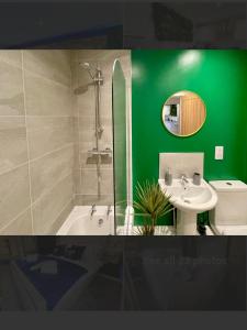 a green bathroom with a sink and a toilet at No 4 Hawthorn View Ground floor apartment in York +11 photos