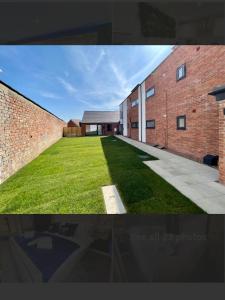 a picture of a brick building with a grass yard at No 4 Hawthorn Ground floor apartment in York