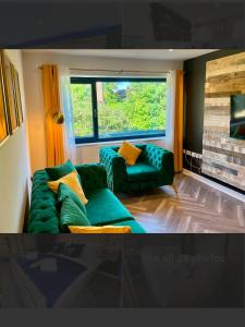 a living room with a green couch and a window at No 4 Hawthorn Ground floor apartment in York