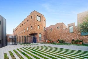 an exterior view of a brick building with a black gate at Pass The Keys Plush Perfection in London