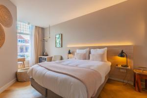 a bedroom with a large bed and a window at City Hotel Rembrandt in Leiden