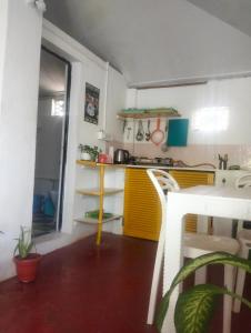uma pequena cozinha com uma cozinha amarela e branca em Anika homes em Canacona