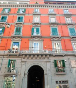 un grande edificio arancione con finestre e ingresso di Casa Pistò in Dante Square a Napoli