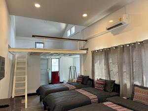 チェンマイにあるProud Chiang Mai Poshtelのベッド4台とロフトベッド1台が備わる客室です。