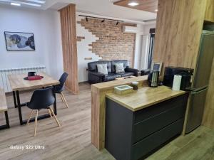 a kitchen and living room with a couch and a table at Serbian home - Gandijeva 184, free parking, blok 44 in Bežanija