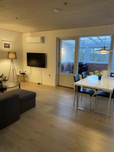 a living room with a table and a tv at Søhusets anneks2 in Viborg