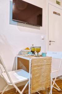 einen Tisch mit einem TV an der Wand und einem Stuhl in der Unterkunft Porta da Muralha de Lisboa 1375 in Lissabon