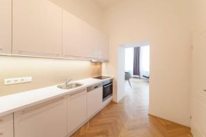uma cozinha com armários brancos e um lavatório em KS70 Apartments em Viena