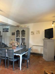 a dining room with a table and chairs and a tv at Gite le Patis in Pré-en-Pail