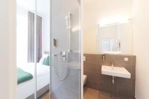 um banheiro com chuveiro e pia em KS70 Apartments em Viena