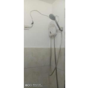 a blow dryer in the corner of a bathroom at Homey Studio Condo by Malou in Calamba