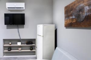 a white refrigerator in a room with a tv at Mirò House in Turin