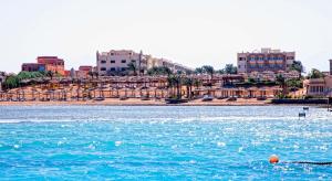 una masa de agua con edificios en el fondo en El Karma Beach Resort & Aqua Park - Hurghada, en Hurghada