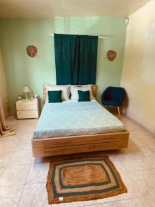 a bedroom with a large bed with a blue curtain at SOFT YLaNG in Dembeni