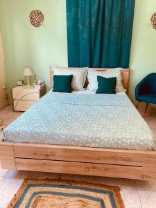- une chambre avec un grand lit et un rideau bleu dans l'établissement SOFT YLaNG, à Dembeni