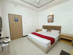 a bedroom with a bed and a telephone in it at Usha Residency in Bhuj