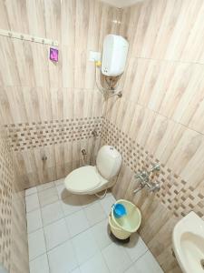 La salle de bains est pourvue de toilettes et d'un lavabo. dans l'établissement Usha Residency, à Bhuj