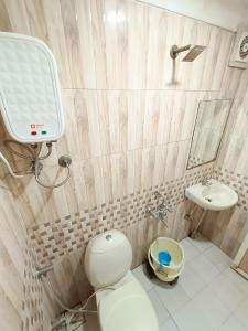 a bathroom with a toilet and a sink at Usha Residency in Bhuj