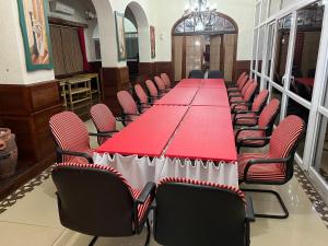einen langen roten Tisch und Stühle in einem Zimmer in der Unterkunft Dodoma Rock Hotel Ltd in Dodoma