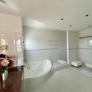 a white bathroom with a tub and a sink at Große sonnendurchflutete Wohnung in Costa Calma