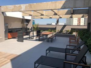 a patio with chairs and a table on a roof at Studio completo luxo novo in Sao Paulo