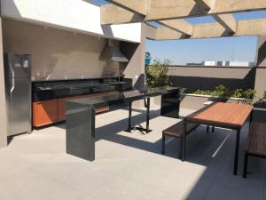 an outdoor kitchen with a table and a bench at Studio completo luxo novo in Sao Paulo