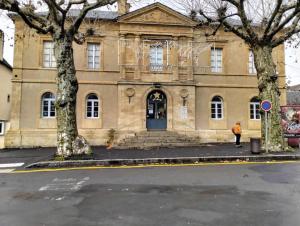 a building with a person walking in front of it at le Petit Pénitent Quartier Doré in Marvejols