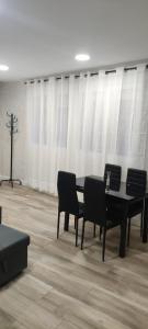 聖塞巴斯蒂安德洛斯雷耶斯的住宿－Apartamento Centro B，一间带桌子和黑色椅子的用餐室