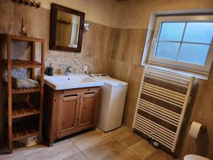 een badkamer met een wastafel en een wasmachine bij Little Farm House, 25164 in Bunde
