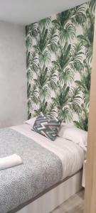 een slaapkamer met een muurschildering van palmbomen bij Apartamento Centro B in San Sebastián de los Reyes