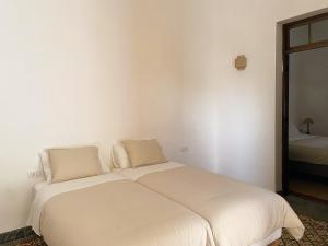 een wit bed in een kamer met een spiegel bij Casa Álvaro in Fasnia