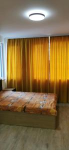 1 dormitorio con 1 cama grande y cortinas amarillas en Sunflower en Sofía