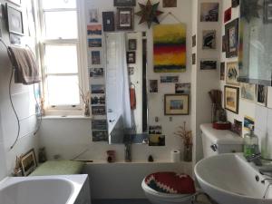 a bathroom with a sink and a toilet and a mirror at Guinness Court Shared Apartment in London