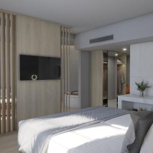 a bedroom with a bed and a flat screen tv at Nireus Hotel in Symi