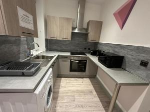 a kitchen with a sink and a washing machine at Serviced Ensuite Double Room - Near Greenwich Park - The O2 Arena - Nearby Transport Links to Central London - New Cross Station - Lewisham SE14 in London