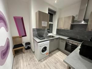 a kitchen with a washing machine and a sink at Serviced Ensuite Double Room - Near Greenwich Park - The O2 Arena - Nearby Transport Links to Central London - New Cross Station - Lewisham SE14 in London