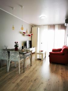 un soggiorno con tavolo e divano rosso di Apartment Ruby a Lloret de Mar