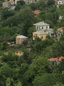a group of houses on a hill with trees at Magical cottage! in Agios Georgios Nilias