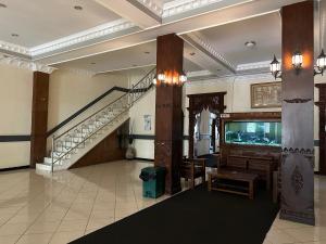 eine Lobby mit einer Treppe und einem Aquarium in der Unterkunft Samudra Hotel in Jepara