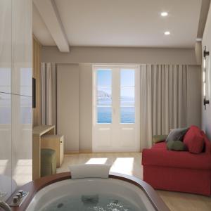 a bathroom with a bath tub and a red couch at Nireus Hotel in Symi