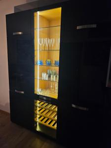 un armario negro con copas de vino. en Tölgyes Apartmanház, en Szeged