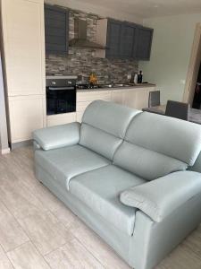 a couch in a living room with a kitchen at Locazione Turistica da Cinzia 