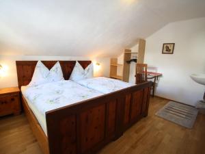 a bedroom with a large wooden bed with white sheets at Beautiful Holiday Home in Filzmoos with Sauna in Filzmoos