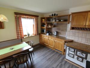 a kitchen with wooden cabinets and a table with chairs at Beautiful Holiday Home in Filzmoos with Sauna in Filzmoos