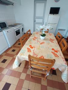 eine Küche mit einem Tisch und Stühlen sowie eine Küche mit einem Tisch und einem Tisch in der Unterkunft Maison individuelle avec jardin in Soulac-sur-Mer