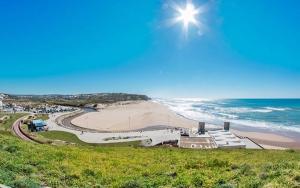 a view of a beach and a white building at Casa da Luísa in Lourinhã